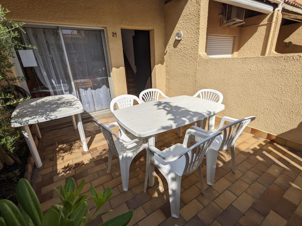 une table blanche et des chaises sur une terrasse dans l'établissement Villa T3 Mezzanine Climatisée, Proche Plage, Parking et Terrasse - 6 Pers - FR-1-797-56, à Port-la-Nouvelle