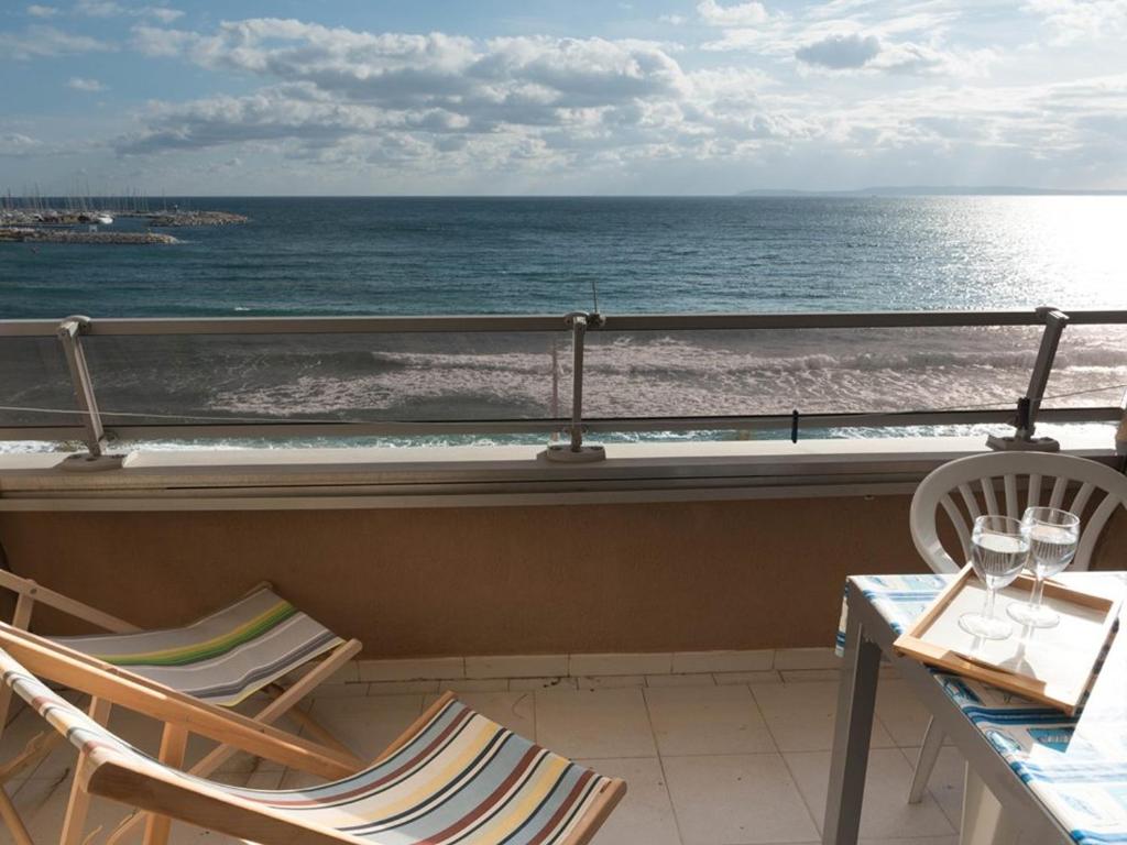 un balcon avec des chaises et une table et l'océan dans l'établissement Studio cabine 4 pers, plage, centre, parking - FR-1-803-35, au Lavandou