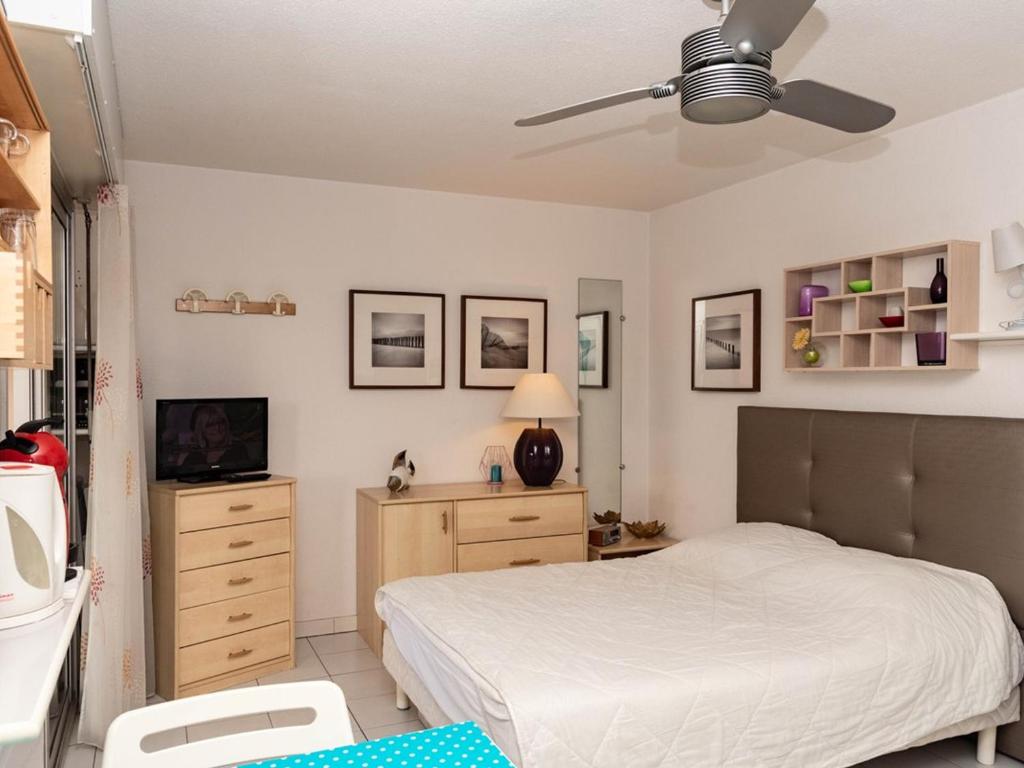 une chambre avec un lit et une télévision dans l'établissement Lavandou: Studio climatisé, terrasse, proche plage, 2 pers. - Pas d'animaux, sans parking - FR-1-803-43, au Lavandou