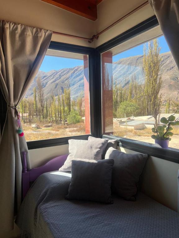a bedroom with a bed and a window with a view at El Descanso del Wayra in Tilcara