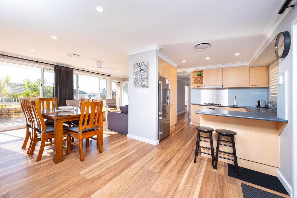 a kitchen and dining room with a table and chairs at Magpie Rest in Forster
