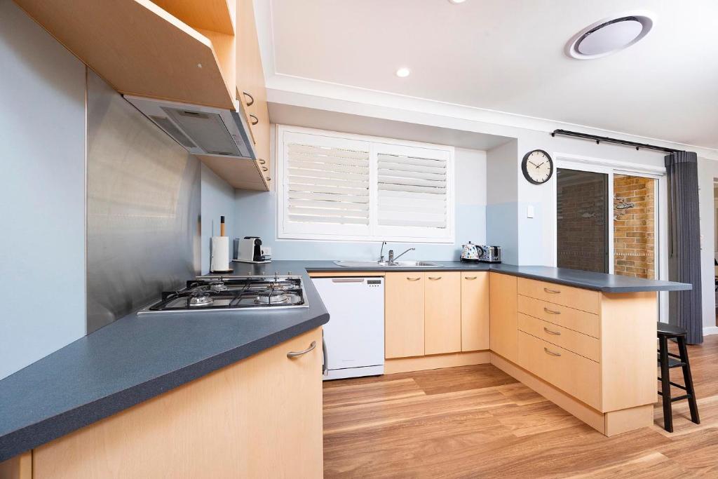 a kitchen with a stove and a counter top at Magpie Rest in Forster