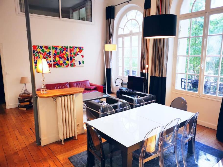 un salon avec une table et un canapé dans l'établissement Beautiful quiet family loft Paris, à Paris