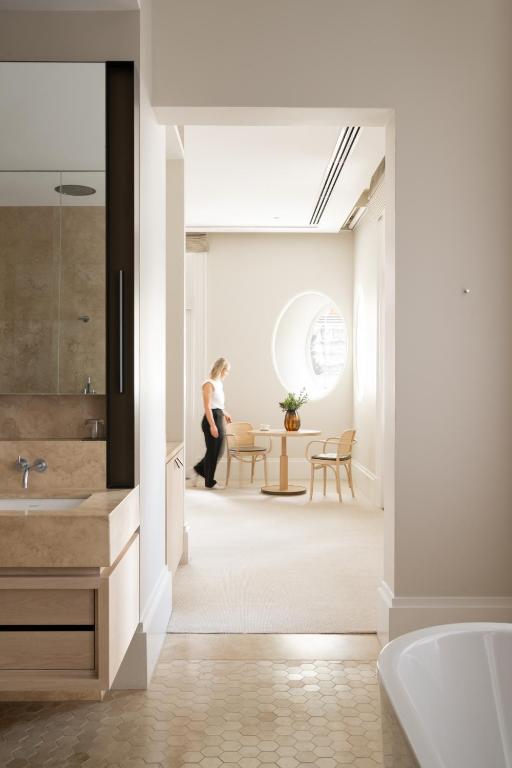 a bathroom with a sink and a person walking into a room at COMO The Treasury in Perth