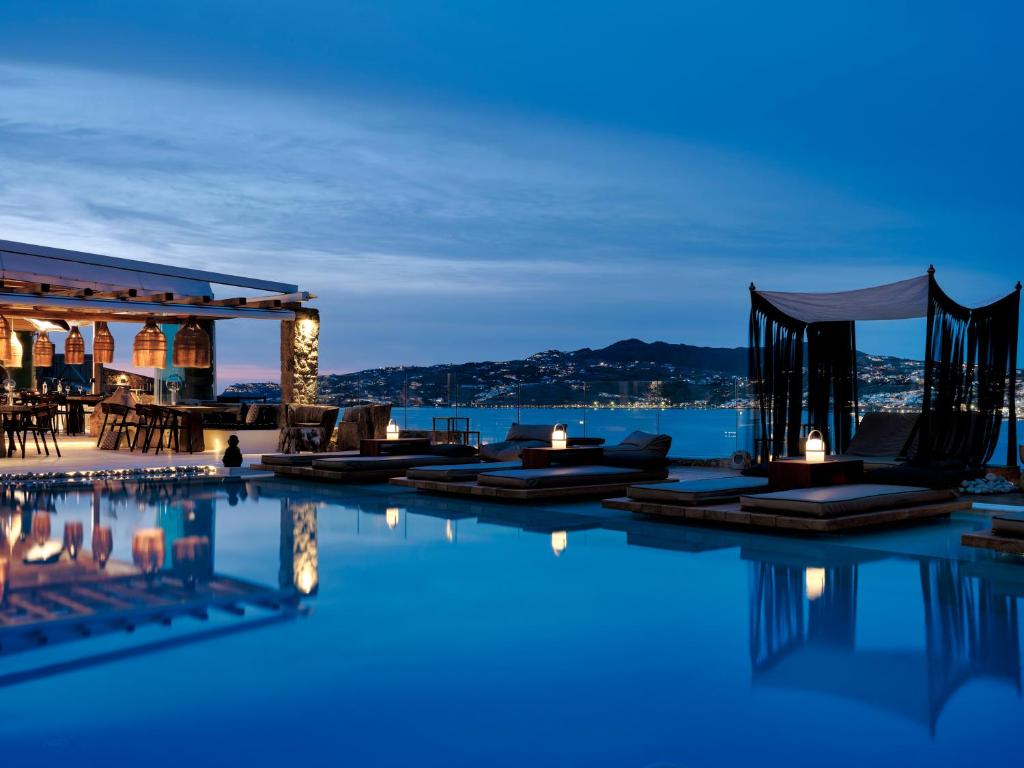 a pool with a view of the water at night at Mykonos No5 Luxury Suites & Villas in Ornos