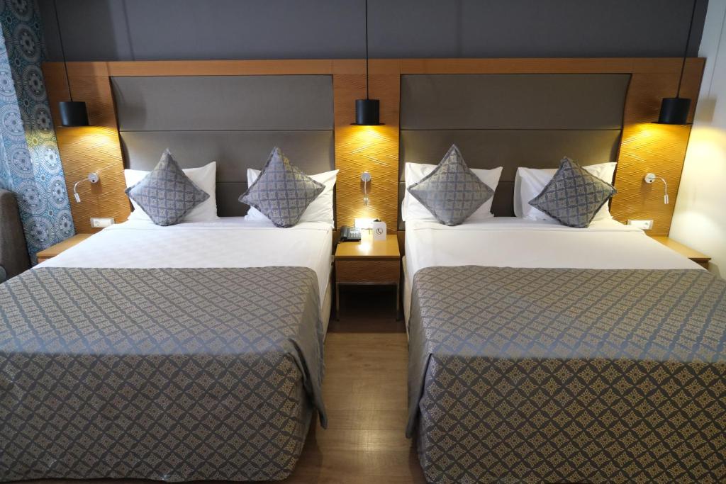 two beds in a hotel room with two twin beds at Liberty Kuşadası in Kusadası