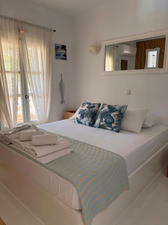 a bedroom with a large bed with a mirror at Simos suites in Elafonisos