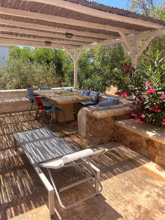a patio with a table and a bench under a pergola at Simos suites in Elafonisos