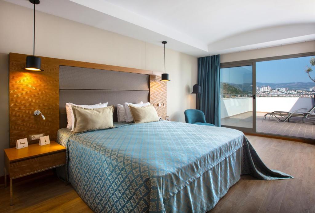 a hotel room with a bed and a balcony at Liberty Kuşadası in Kusadası