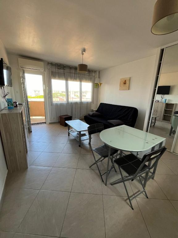 un salon avec une table et un canapé dans l'établissement BEAU STUDIO CLIMATISE Rive Gauche, à Palavas-les-Flots