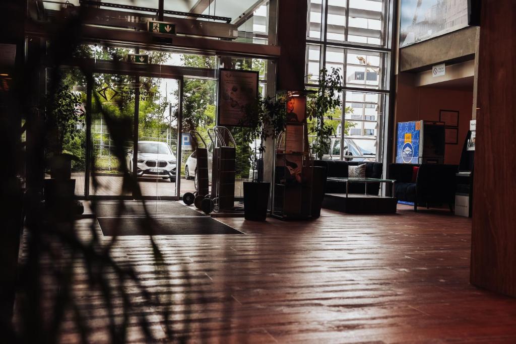 eine leere Lobby mit einer Glastür und einem Auto davor in der Unterkunft Park Hotel Diament Katowice in Kattowitz
