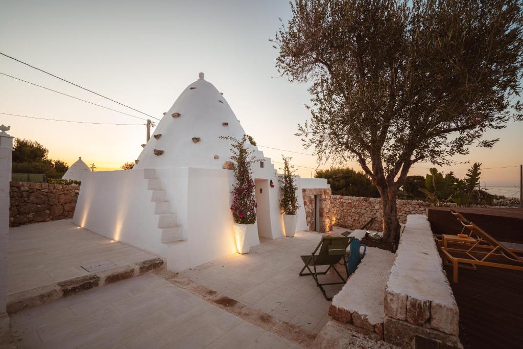 a white house with a christmas tree on a patio at TrulloMare Villa Sea View & Pool - Housea in Polignano a Mare