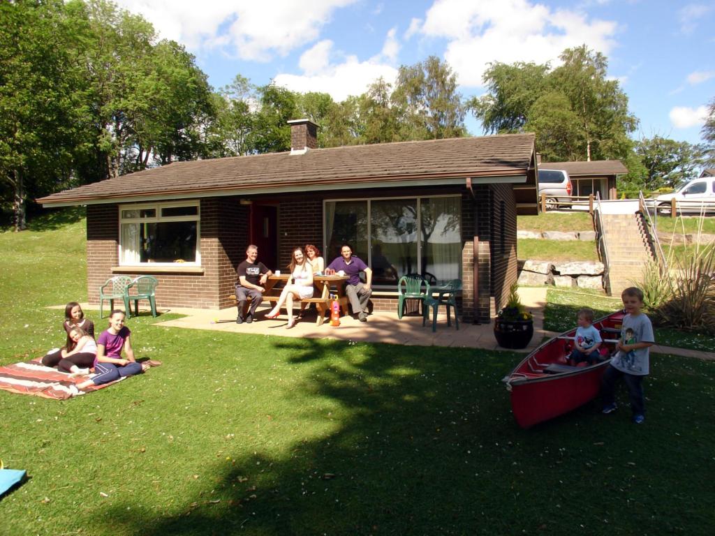 eine Gruppe von Menschen, die auf dem Hof eines Hauses sitzen in der Unterkunft Manor House Marine & Cottages in Irvinestown