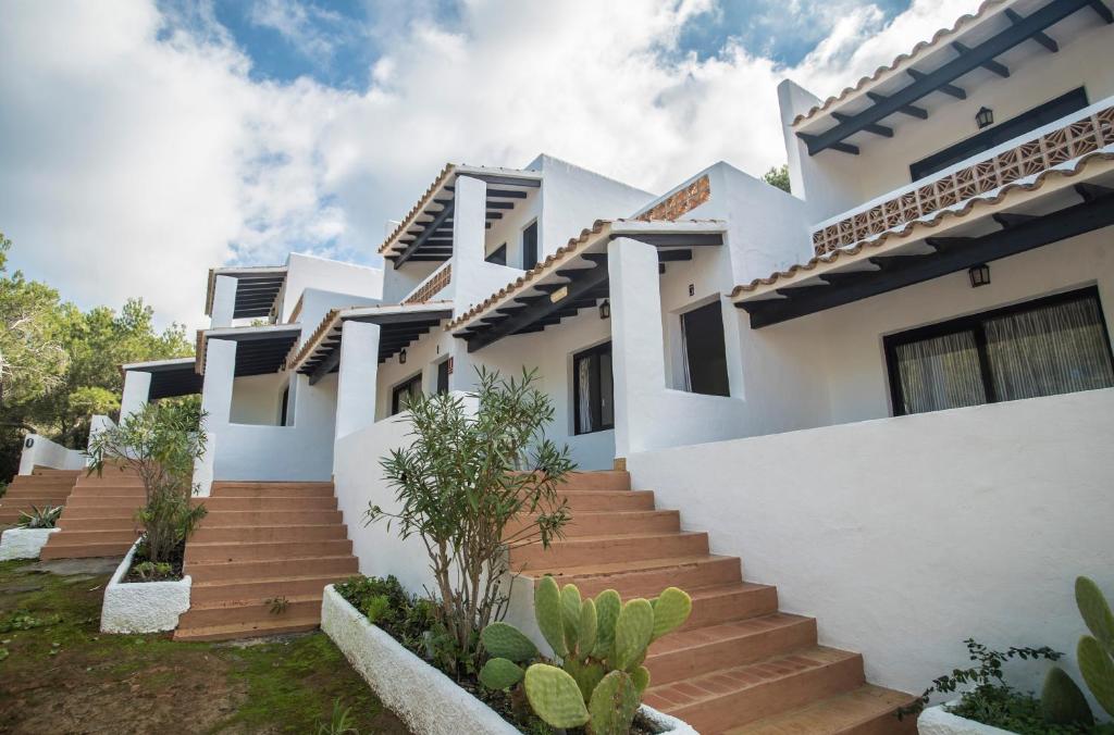 dom z białymi ścianami i schodami w obiekcie Pinomar - Emar Hotels w mieście Es Calo