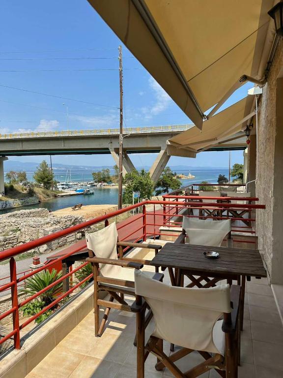 a balcony with tables and chairs and a bridge at Canal Luxury Apartments in Nea Potidaea
