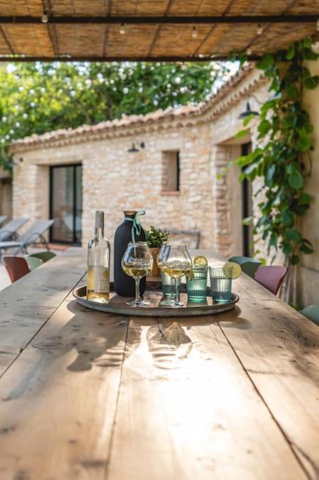 un plateau de verres à vin et de bouteilles sur une table en bois dans l'établissement Villa Privée au Cœur du Luberon - Piscine Jardin, à Pertuis