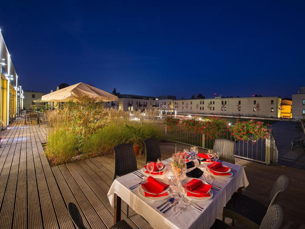 una mesa de comedor en una terraza por la noche en EA Hotel Tereziánský dvůr, en Hradec Králové