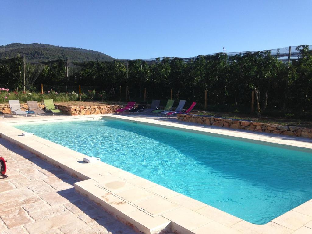 a swimming pool with blue water and lounge chairs at Les Jardins de Bouteille in Manosque