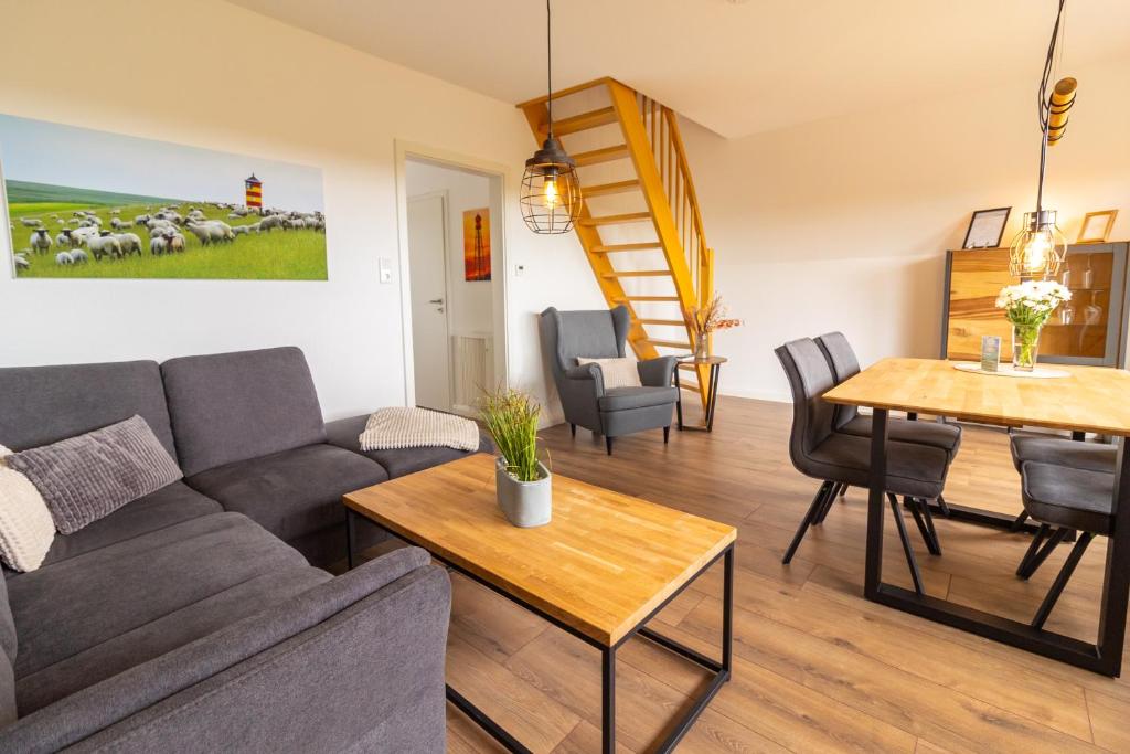 a living room with a couch and a table at Deichblick No1 in Krummhörn