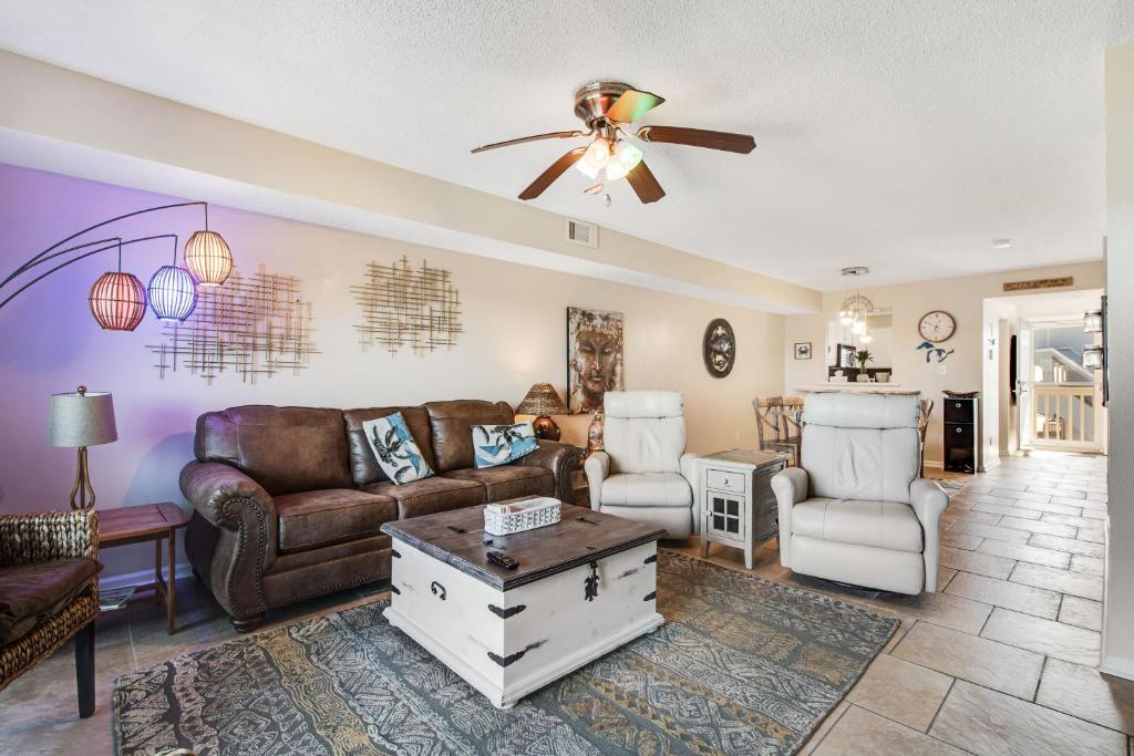 a living room with a couch and a ceiling fan at Summer House West Condos in Gulf Shores