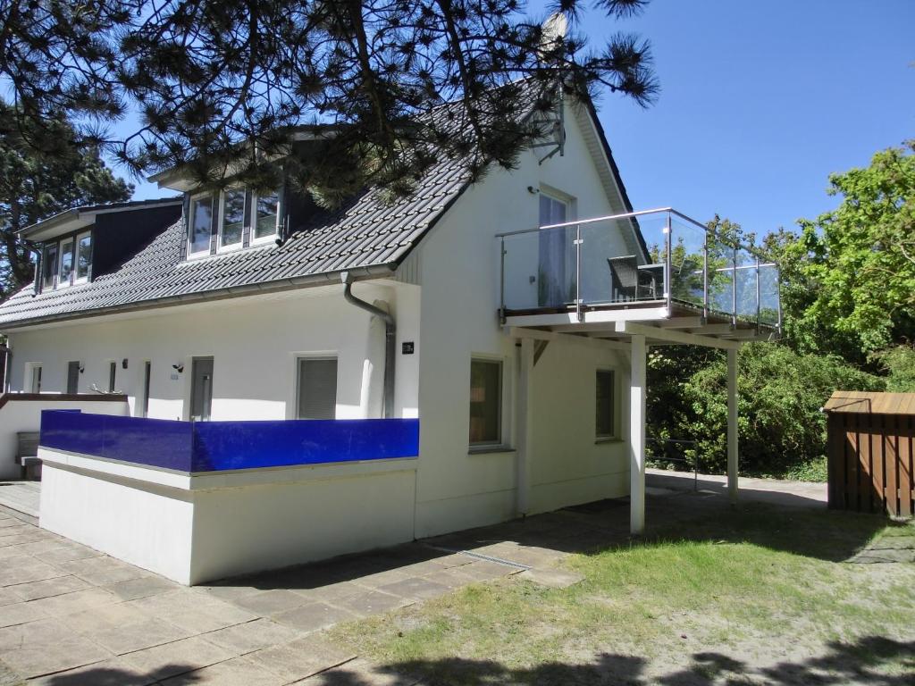 a house with a balcony on the side of it at Markgrafenheide Ferienhaus MH4 - "Strandhaus" in Markgrafenheide