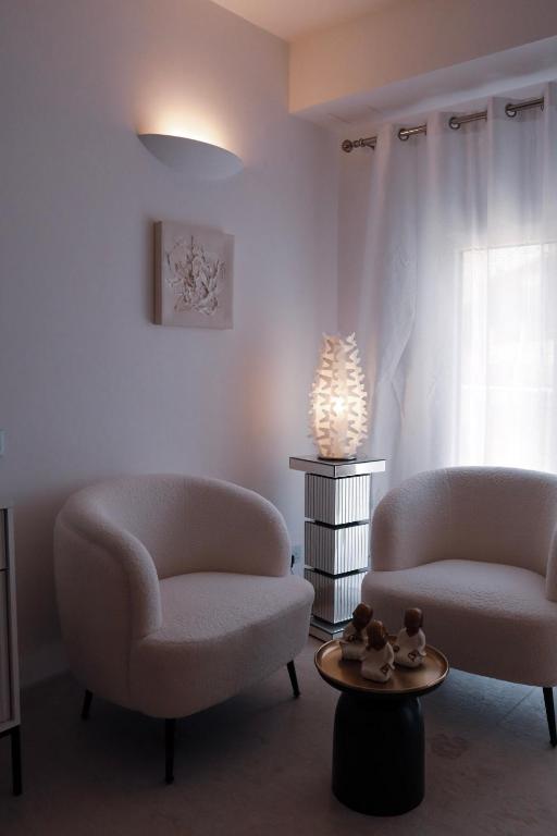 two chairs and a table in a living room at The White Knight Premium Boutique Hotel in Għajnsielem