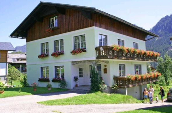 a large house with people standing outside of it at Ferienwohnungen Klose in Gosau