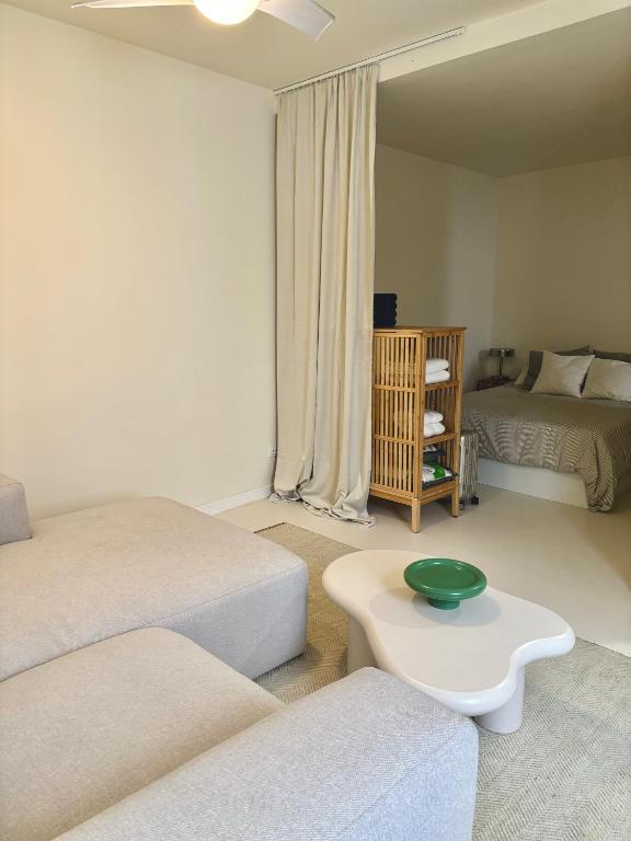 una sala de estar con dos camas y un cuenco verde sobre una mesa en Casa Paloma en el centro de Madrid, en Madrid
