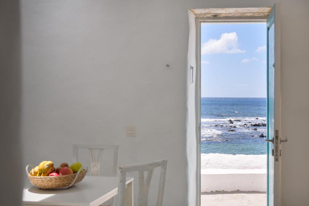eine Schale mit Obst auf einem Tisch mit Meerblick in der Unterkunft Casa el Alto - Lava in Punta de Mujeres