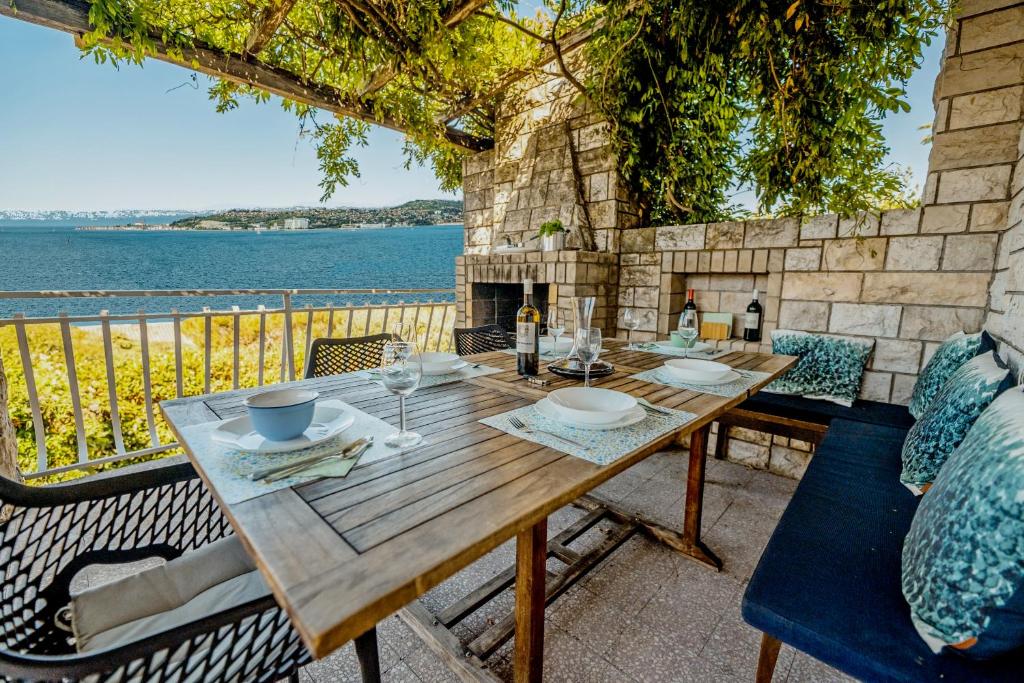 a wooden table on a patio with a view of the water at Casa Monterosso - great sea view, free parking, large terrace, near the sea in Crveni Vrh