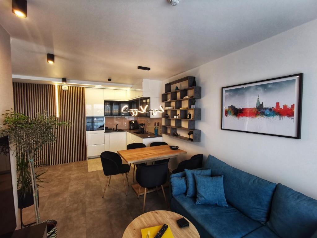 a living room with a blue couch and a table at Smart Apartament Grunwaldzka 240 in Poznań