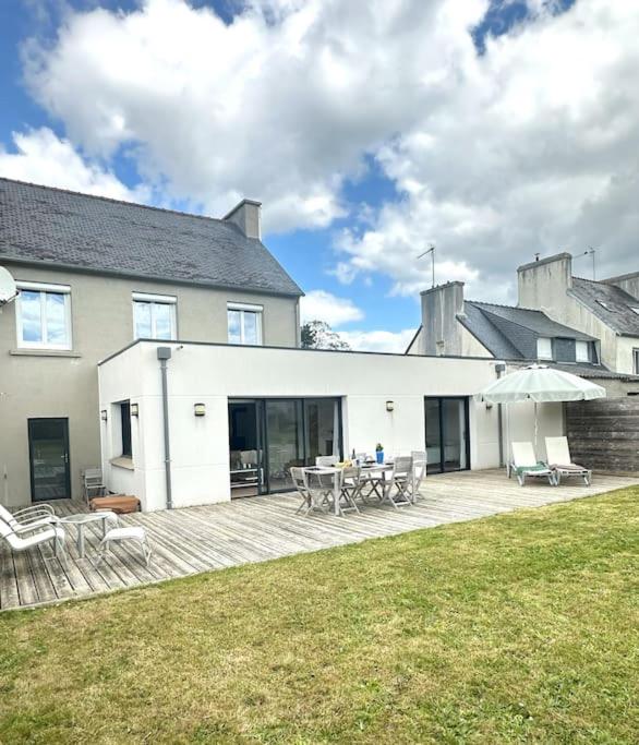 une maison avec une terrasse dotée d'une table et d'un parasol dans l'établissement Grande Maison - Proche plages - Combrit Ste Marine, à Combrit
