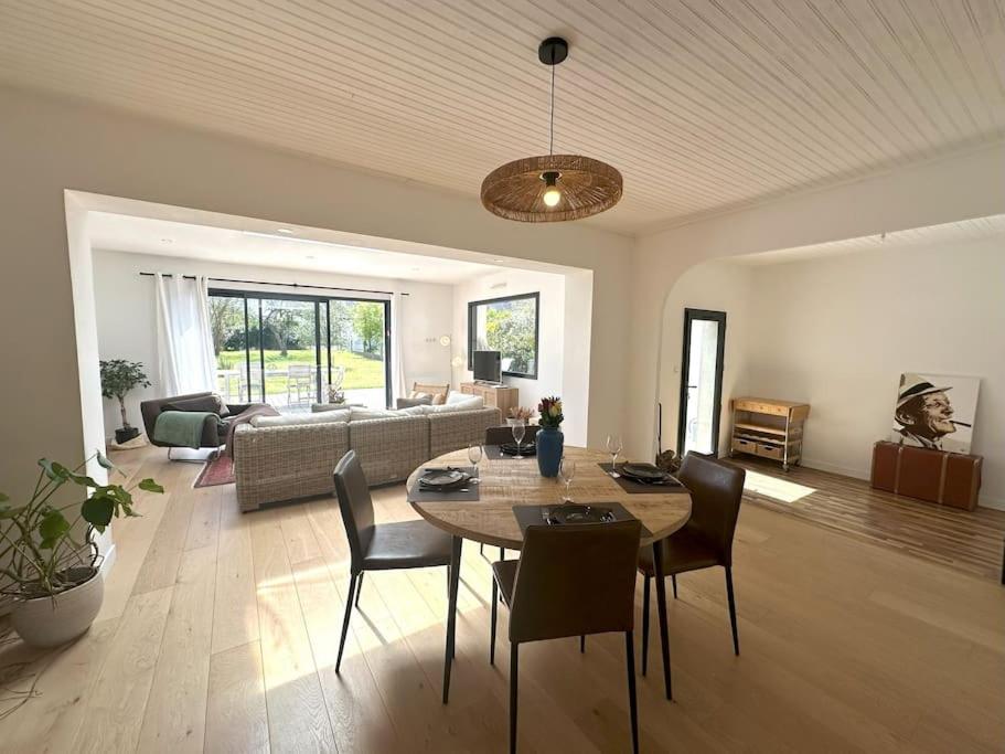 a living room with a table and chairs and a couch at Grande Maison - Proche plages - Combrit Ste Marine in Combrit
