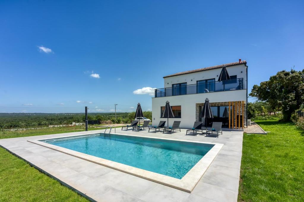 a villa with a swimming pool in front of a house at Villa Speranza in Selina