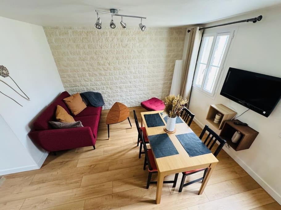 un salon avec un canapé rouge et une table dans l'établissement Appartement quartier centre historique, à Caen