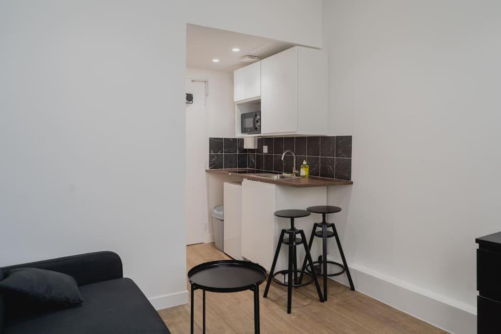 Il comprend un salon avec un canapé et une cuisine avec des tabourets. dans l'établissement Studio Gorgeat, à Chambéry