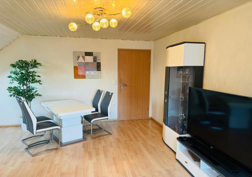 a living room with a table and chairs and a television at Ferienunterkunft Monteurwohnung Hagenbach in Hagenbach