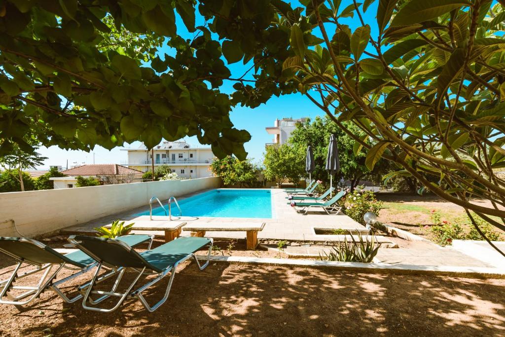 a swimming pool with lounge chairs and a table and a swimming pool at Chania Dream House in Chania