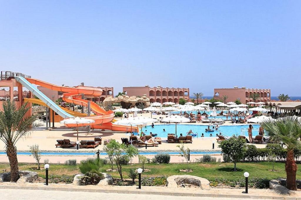 Three Corners Happy Life Beach Resort في أبو دباب: مسبح مع زحليقة وحديقة مائية