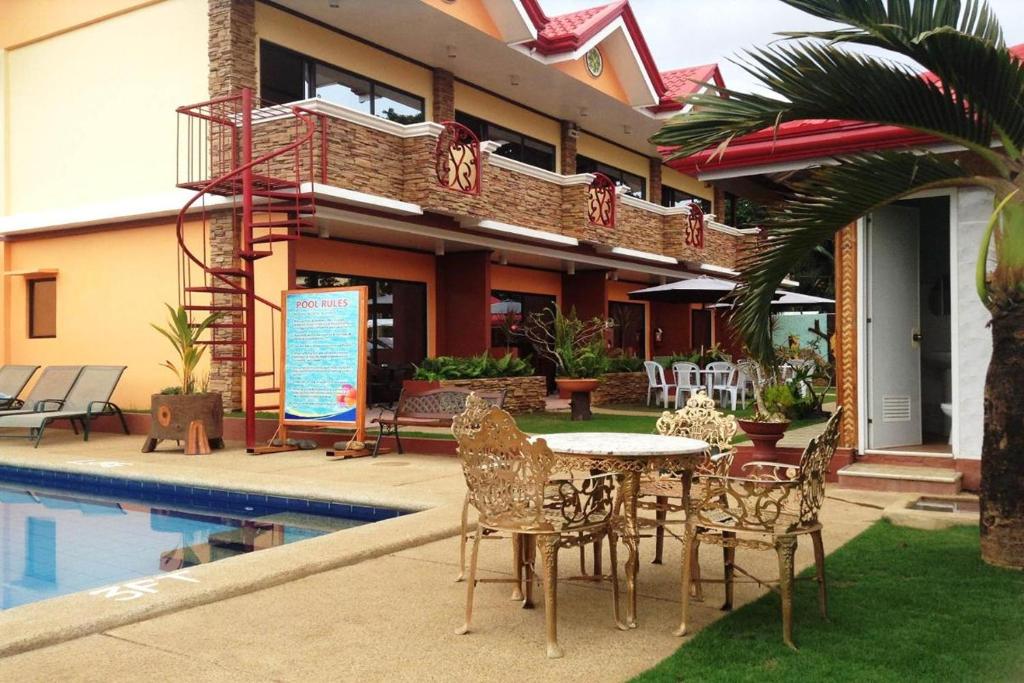 a patio with a table and chairs next to a building at Citadel Bed and Breakfast in Puerto Princesa City