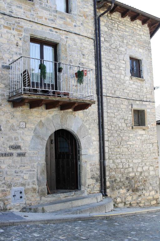 a stone building with a door and a balcony at Casa Rural Borau in Borau