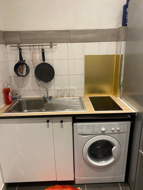 a kitchen with a sink and a washing machine at Sci h3 communes in Montreuil