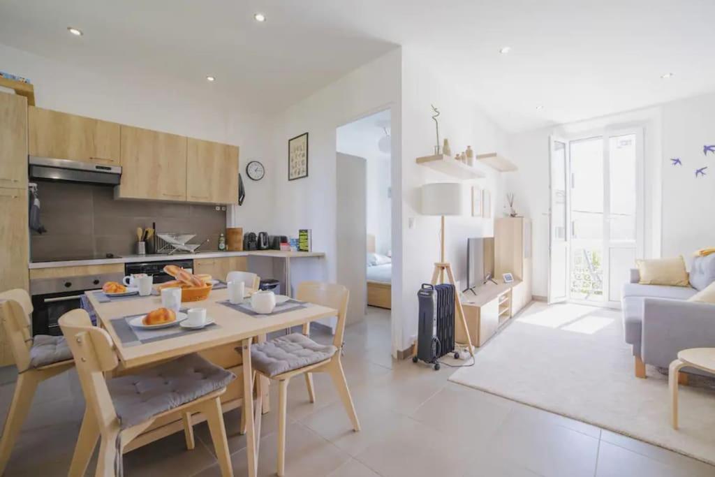 une cuisine et un salon avec une table et des chaises dans l'établissement Appartement familial, lumineux, calme avec parking, à Cannes