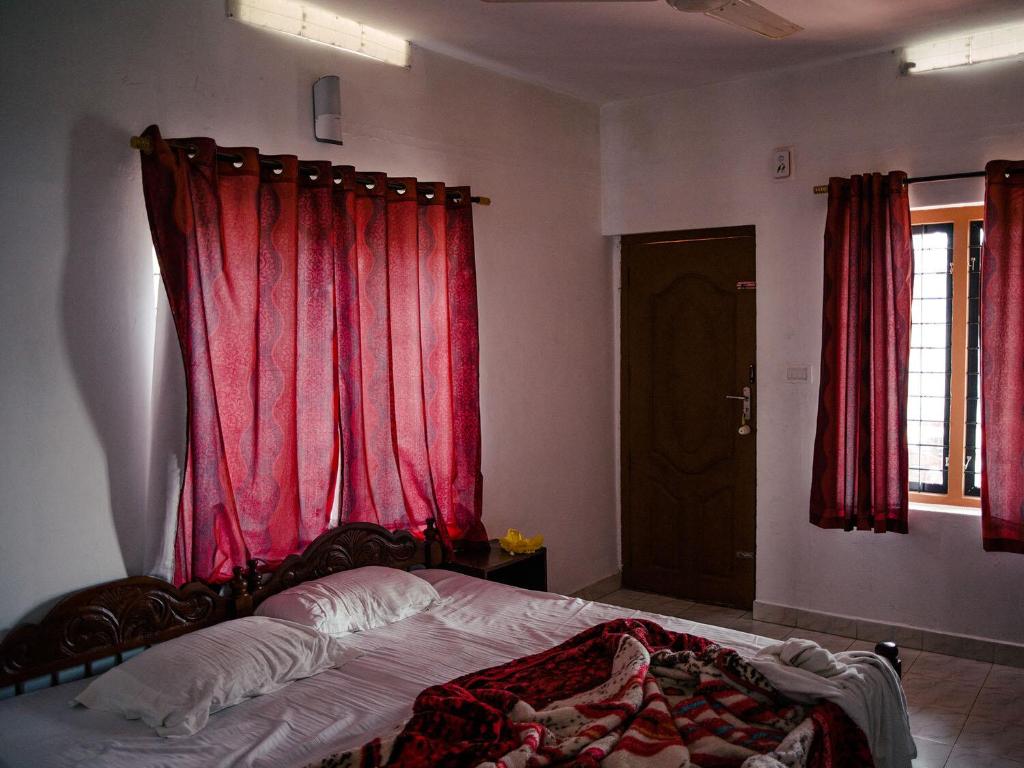una camera da letto con letto e tende rosse di Depak hotel a Janakpur