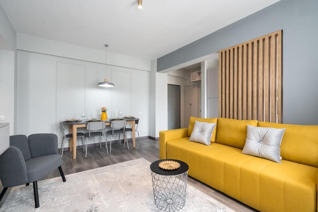 a living room with a yellow couch and a table at Dreamy City Center in Bucharest