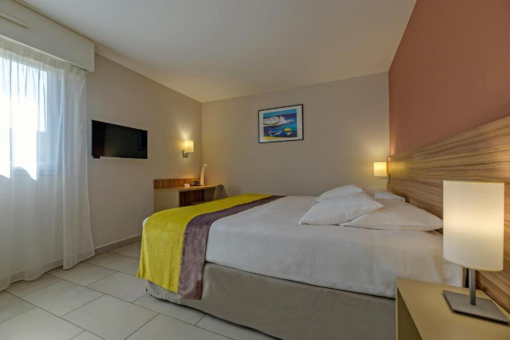 a hotel room with a bed and a window at Best Western Plus Ajaccio Amirauté in Ajaccio