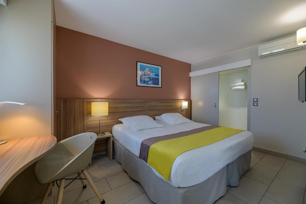 a bedroom with a bed and a desk and a chair at Best Western Plus Ajaccio Amirauté in Ajaccio