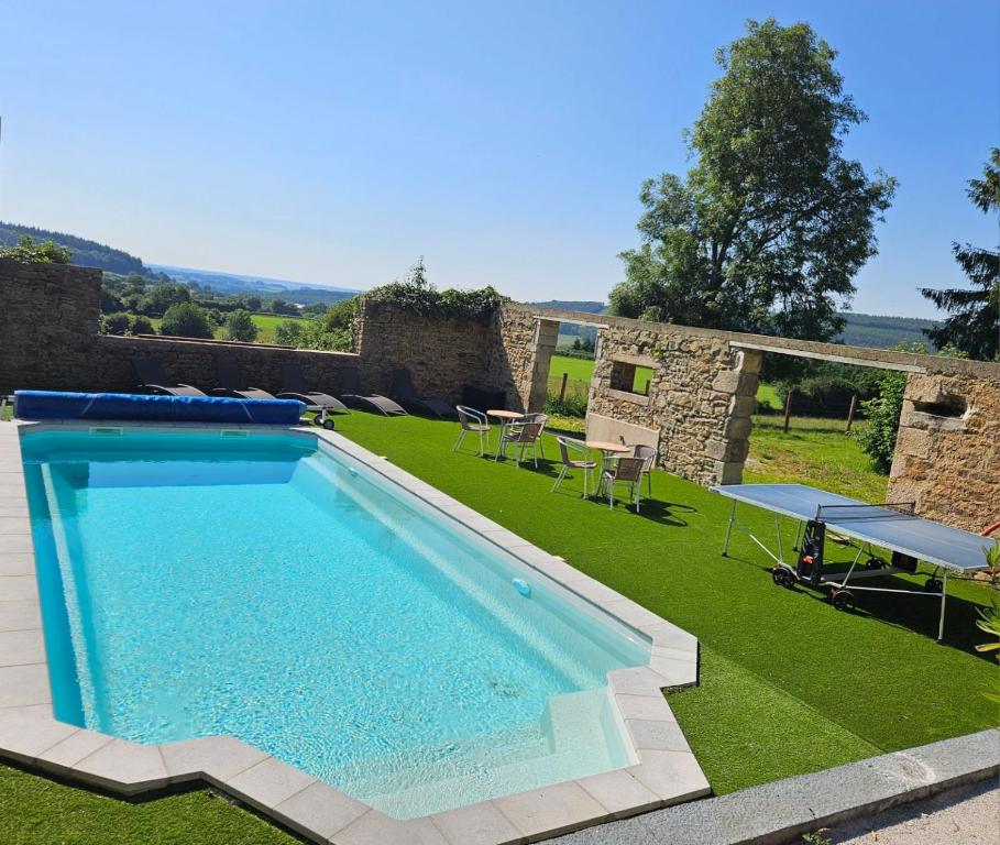 - une piscine au milieu d'une cour avec de l'herbe dans l'établissement Au fer à cheval, à Gandelain