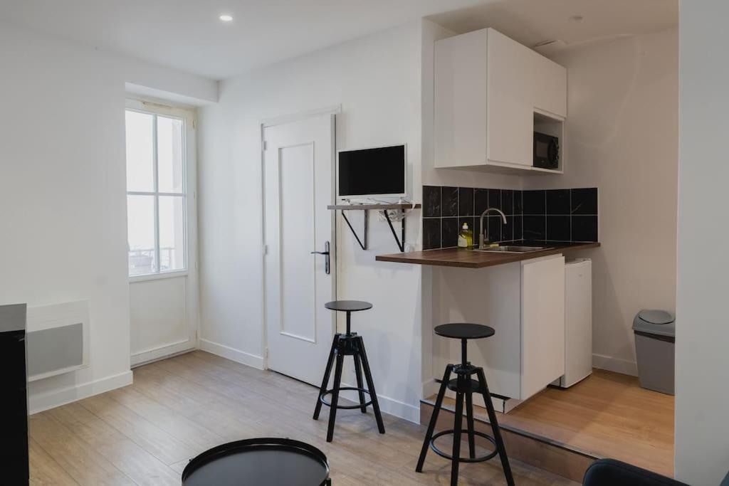 une cuisine avec deux tabourets de bar et un comptoir dans l'établissement Studio La Dent du Chat, à Chambéry