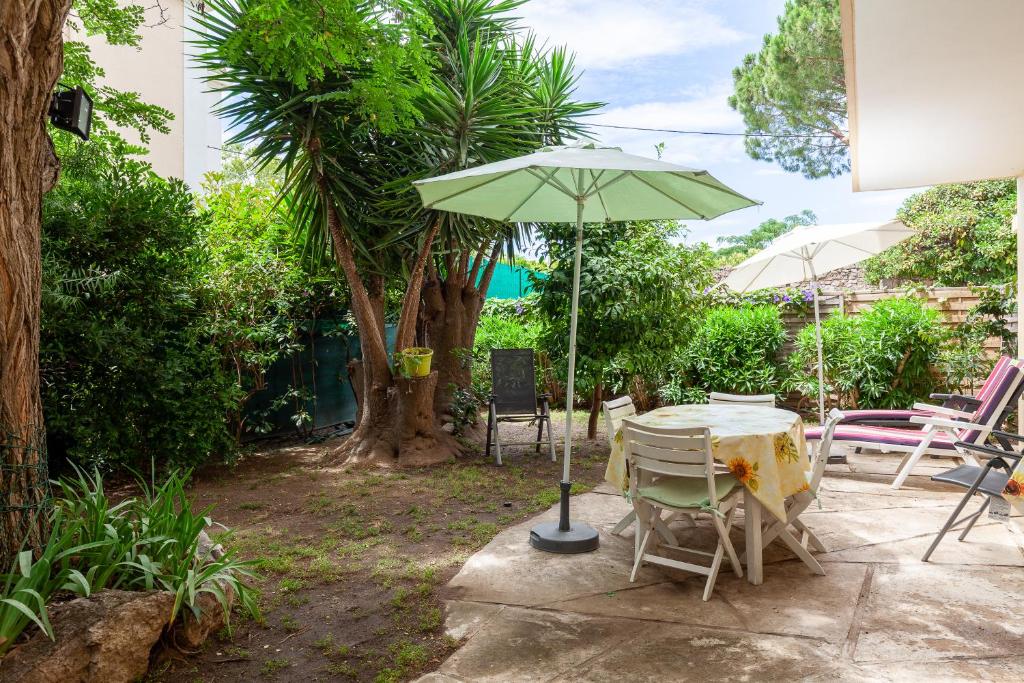 une table et des chaises avec un parasol sur une terrasse dans l'établissement Appartement dans cadre de verdure, à La Seyne-sur-Mer